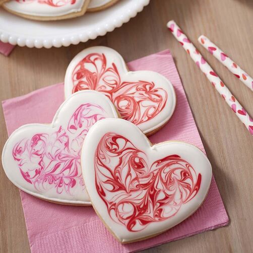 Heart-Swirl-Cookies Heart-shaped cookies with marbleized royal icing in white, red, and pink