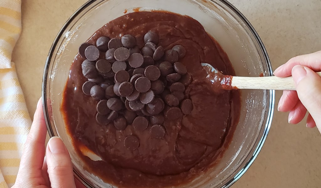 One-bowl brownie Step 6- Add mix-ins chocolate chips being mixed into a bowl of brownie mix