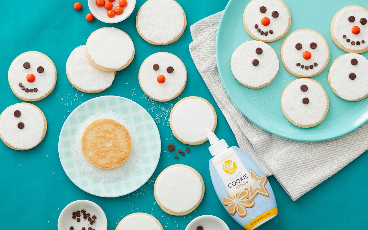 decorating-snowman-cookies Using white cookie icing to decorate snowman sugar cookies