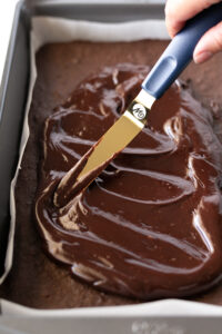 Spread ganache onto brownies in baking pan