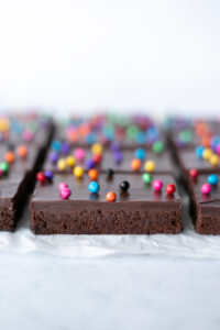 Side view of brownies topped with ganache and Rainbow Chip Crunch Sprinkles